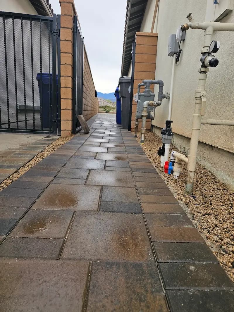 A close-up image of a brick path along the side of a house, which was previously just dirt.