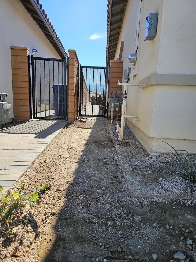 The side of a house that has been leveled and has nice gates installed.